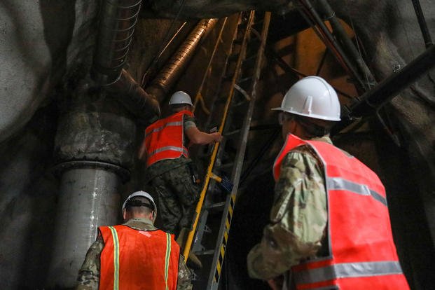 Joint Task Force-Red Hill (JTF-RH) communications directorate personnel climb a ladder