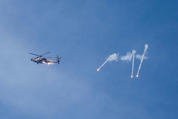 An Israeli Apache helicopter releases flares while patrolling over the Israel- Gaza border
