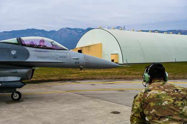 U.S. Air Force Capt. James Mizell, 510th Fighter Squadron pilot, and U.S. Air Force Senior Airman Brice Hixon, 510th Fighter Generation Squadron F-16 Fighting Falcon crew chief, communicate to each other before a takeoff for the Agile Combat Employment Exercise Fighting Wyvern at Aviano Air Base, Italy.