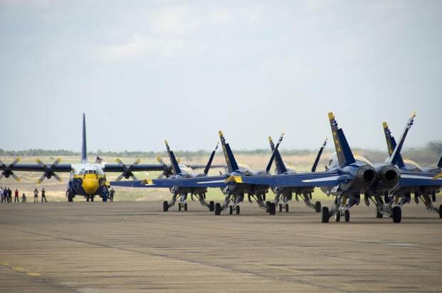 Boeing F/A-18 Hornets assigned to the U.S. Navy flight demonstration squadron, the Blue Angels, taxi past Fat Albert, a C-130 Hercules, at Naval Air Station Meridian. 