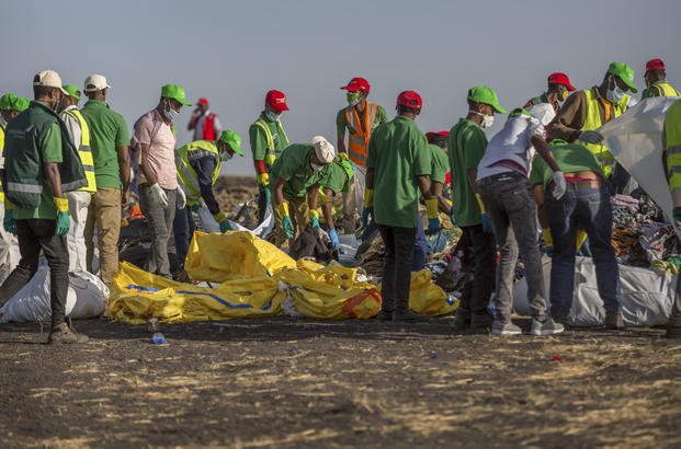 Workers collect debris at the scene where an Ethiopian Airlines Boeing 737 Max 8 crashed