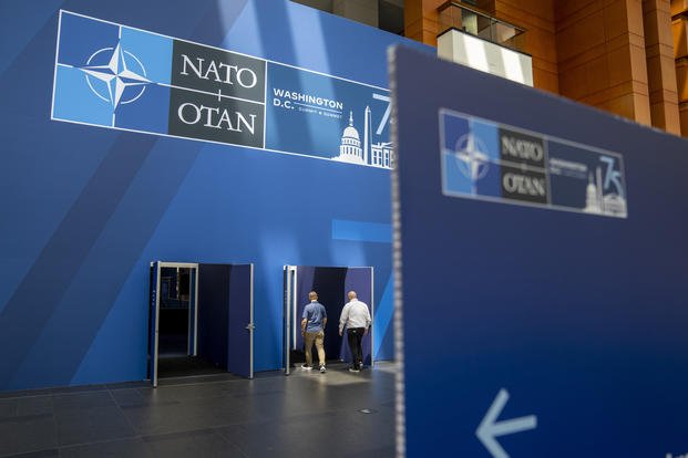 People walk inside of the Walter E. Washington Convention Center, which has been decorated with signage