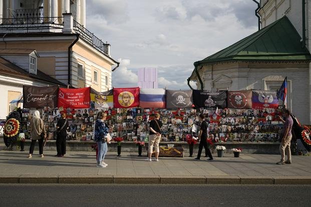 People stand near an improvised memorial to Russian mercenary chief Yevgeny Prigozhin and others who died in a plane crash