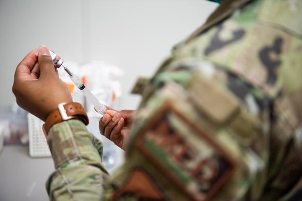 U.S. Air Force Staff Sgt. Jabreanna Fontenot, 18th Operational Medical Readiness Squadron medical technician, draws a vaccine into a syringe at Kadena Air Base, Japan,