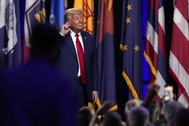 Republican presidential nominee former President Donald Trump puts his hand to his ear