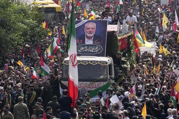 Iranians follow a truck carrying the coffins of Hamas leader Ismail Haniyeh and his bodyguard