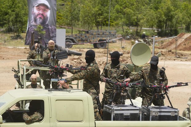 Hezbollah militants take part in an exercise with armed drones 