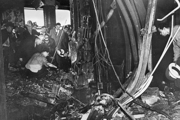 Firemen and other investigators look at the damage done in an office on the 79th floor of New York's Empire State Building by a B-25 bomber, July 28, 1945. 