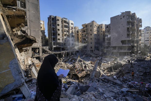 A woman reads the Quran at the site of the assassination of Hezbollah leader Hassan Nasrallah.