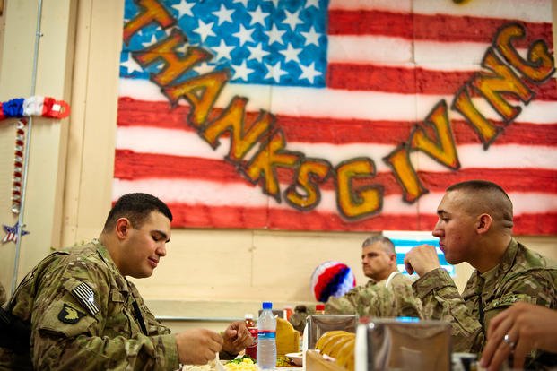 U.S. soldiers at Forward Operating Base Finley-Shields, Afghanistan, sit down for a mid-afternoon Thanksgiving meal.