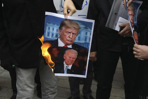 Protesters in Iran burn pictures of Donald Trump and Joe Biden