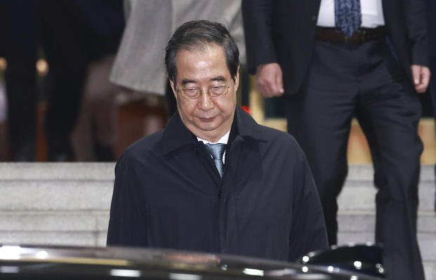 Impeached South Korean acting President Han Duck-soo leaves the government complex building in Seoul, South Korea