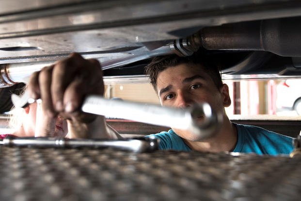 Senior Airman Igor Pacheco, 56th Medical Support Squadron lab technician, reaches for a wrench while replacing an exhaust system on his vehicle in the Auto Hobby Shop at Luke Air Force Base, Ariz. 