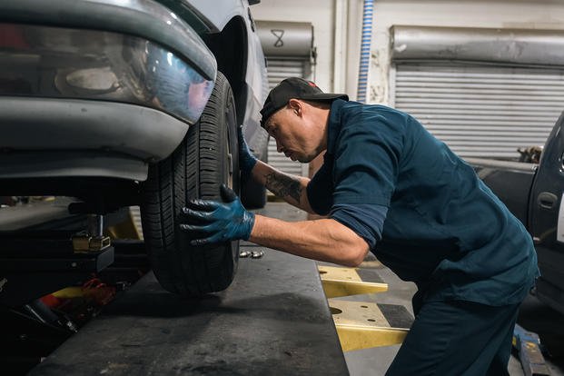 Ara Rinderle, Langley Auto Skills Center automotive technician, reinstalls a tire at Joint Base Langley-Eustis, Virginia.