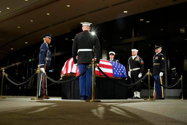 The Guard of Honor surrounds the flag-draped casket of former President Jimmy Carter.