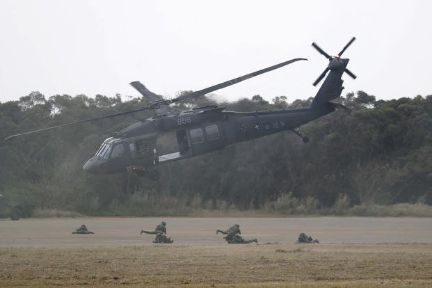 A helicopter flies over soldiers during a military exercise in Hsinchu County, northern Taiwan