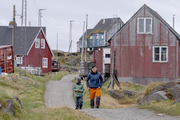 Local residents walk in the settlement Attu, in the Qeqertalik municipality, western Greenland