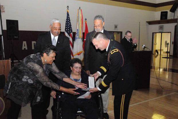 Former Pfc Don Dingee (left) with 3rd Infantry Division soldiers at unveiling of statue showing Dingee being dragged to safety by Medal of Honor recipient Pfc Charles Johnson. (Photo Credit U.S. Army). Statue sof MoH recipient Pfc Charles Johnson