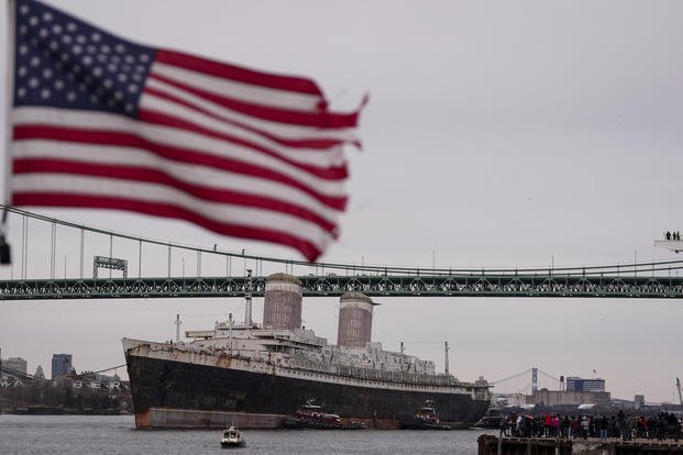 The SS United States is towed down the Delaware River between Pennsylvania and New Jersey, from Philadelphia