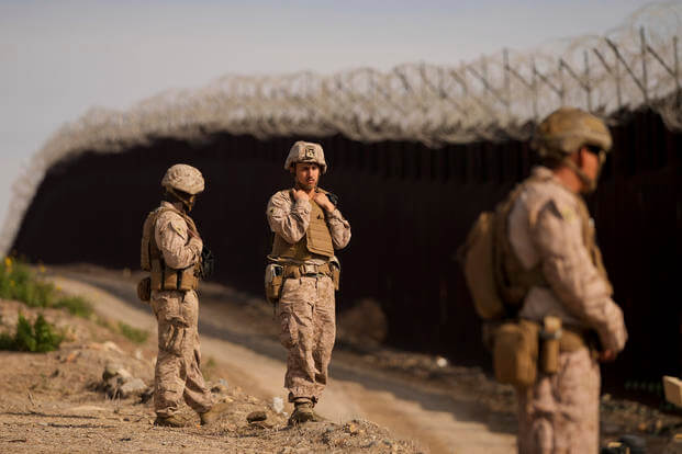 U.S. Marines install barbed wire along the border fence in San Diego