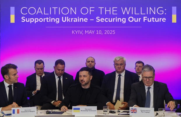France's President Emmanuel Macron, Ukrainian President Volodymyr Zelenskyy and British Prime Minister Keir Starmer sit at a table. 