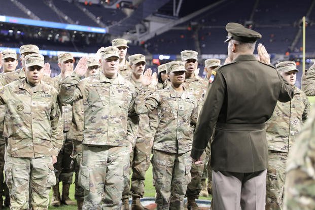 U.S. Army Gen. Andrew Poppas, commander of the U.S. Army Forces Command, performs the oath of enlistment for Army Reserve soldiers assigned to various units in the Chicagoland area before a Chicago Bears Salute to Service game at Soldier Field.
