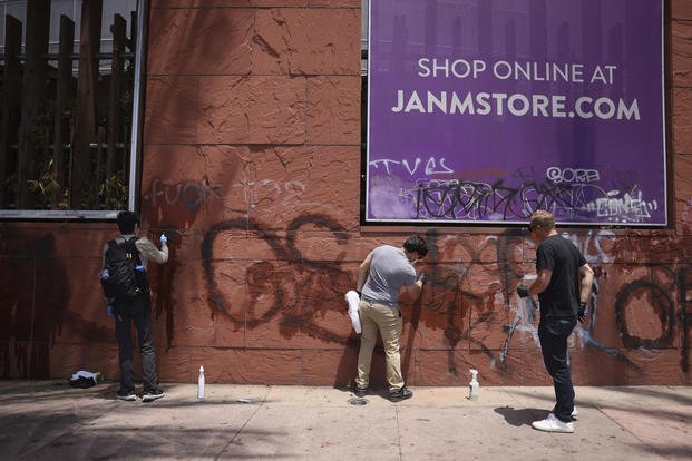 Volunteers remove graffiti from the Japanese American Museum
