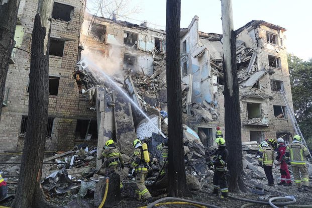 Firefighters work to extinguish a fire in an apartment building after a Russian attack in Kyiv, Ukraine