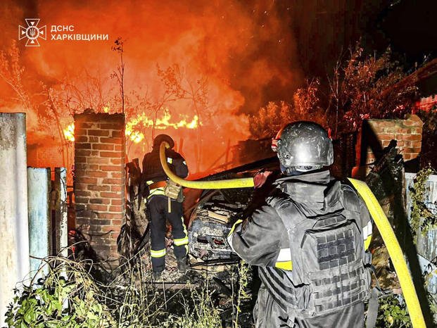  firefighters try to put out a fire following a Russian attack in Kharkiv region, Ukraine