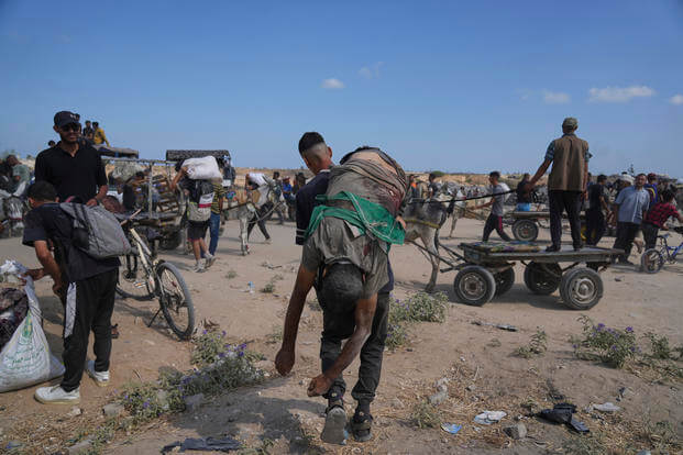 A Palestinian carries the body of a man killed while trying to receive aid