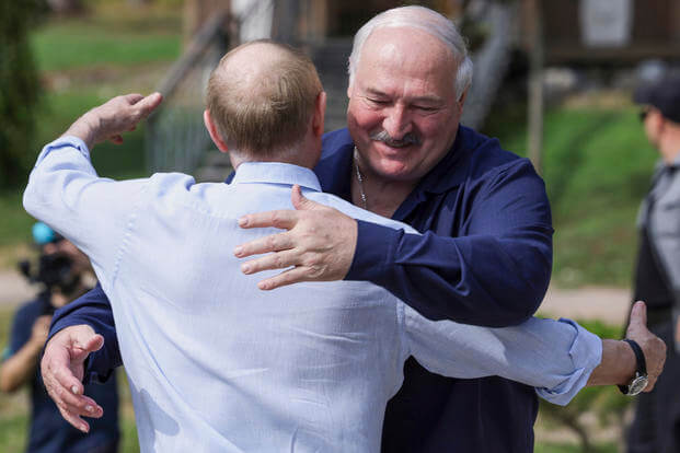 Russian President Vladimir Putin, front, embraces Belarusian President Alexander Lukashenko