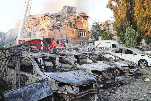 Firefighters work on the site of a burning building after a Russian attack in Kyiv, Ukraine