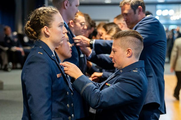 Family and friends pin Officer Training Course badges on graduating U.S. Space Force Guardians