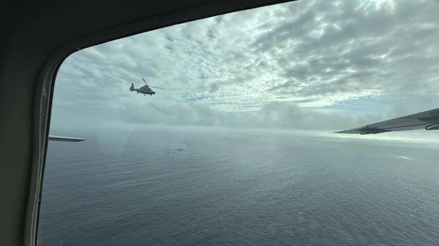 A Chinese military helicopter flies close to a Philippine Bureau of Fisheries and Aquatic (BFAR) aircraft above Scarborough shoal