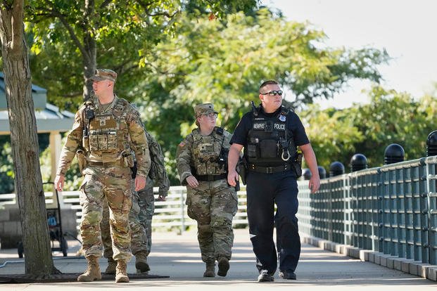A Memphis Police Department officer patrols with members of the National Guard in Memphis, Tenn. 