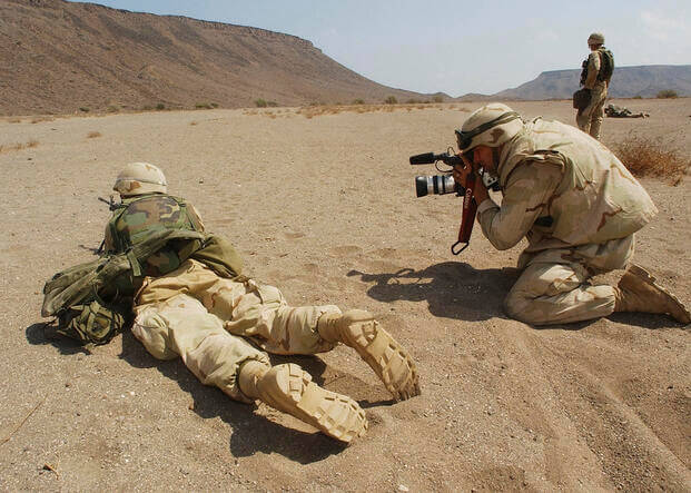 A military photographer taking photos on the battlefield.