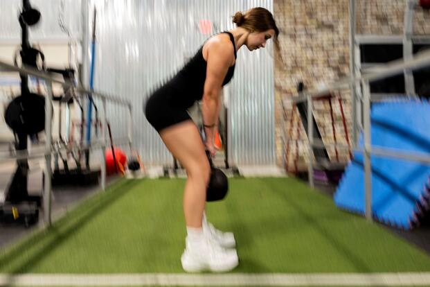Veteran performs lift in gym.