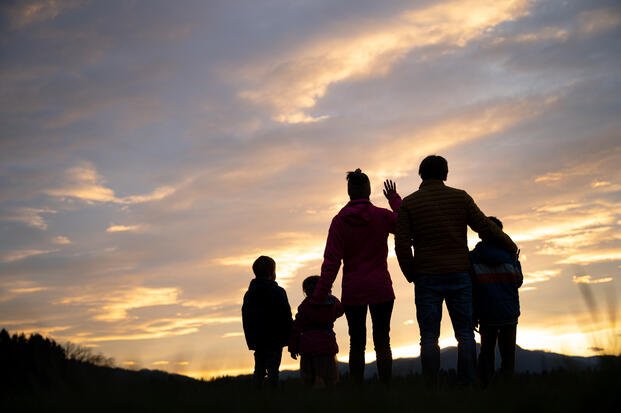 Family standing in sunset
