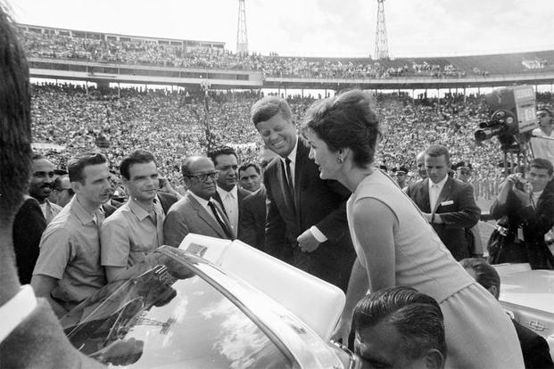 President John F. Kennedy and First Lady Jacqueline Kennedy stand in an open car to greet members of the 2506 Cuban Invasion Brigade at the Orange Bowl Stadium in Miami, Florida, December 29, 1962. (White House photo by Cecil W. Stoughton)
