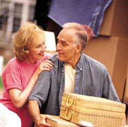 A retired couple moves boxes.