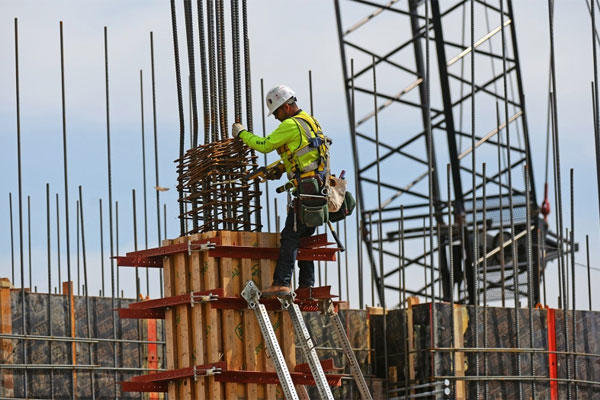 A man works on a concrete form during construction of a new VA hospital in Aurora, Colo.