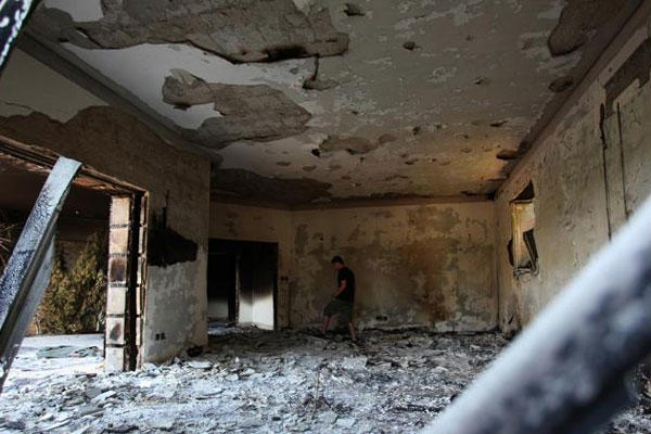 This Sept. 13, 2012 file photo shows a Libyan man walking in the rubble of the damaged U.S. consulate, after an attack that killed four Americans, including Ambassador Chris Stevens on, Sept. 11, 2012, in Benghazi, Libya. (AP Photo/Mohammad Hannon, File)