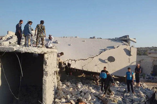 Syrian citizens check a damaged house targeted by the coalition airstrikes in the village of Kfar Derian, a base for the al-Qaida-linked Nusra Front, a rival of the Islamic State group, Tuesday Sept. 23, 2014. (AP Photo/Edlib News Network ENN)