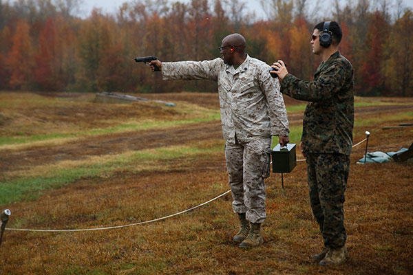A Marine single-handedly shoots an M9 Beretta down range while carrying an ammo can in the other hand during the Quantico Shooting Team's 2015 Combat Shooting Match on Marine Corps Base Quantico, Oct. 26-30. (U.S. Marine Corps/Cpl. Kathy Nunez)