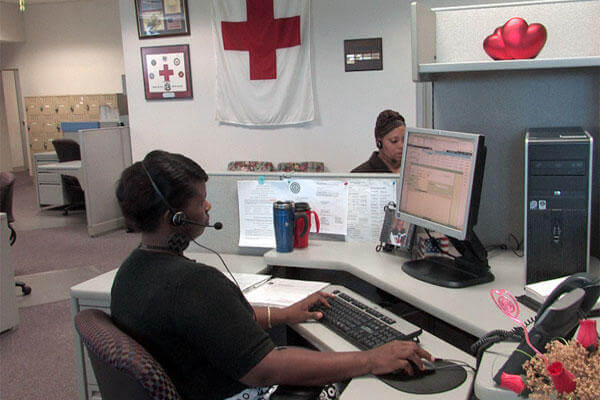 An American Red Cross worker process an emergency message from the Red Cross emergency message hotline. (Photo: American Red Cross)