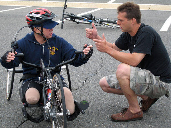Steve Nardizzi explains the brakes on the handcycle to Elmer Dinglasan, a Navy corpsman participating in the second leg of Soldier Ride 2006, from Washington, D.C., to Camp Lejeune N.C. (Photo by Sgt. Sara Wood)