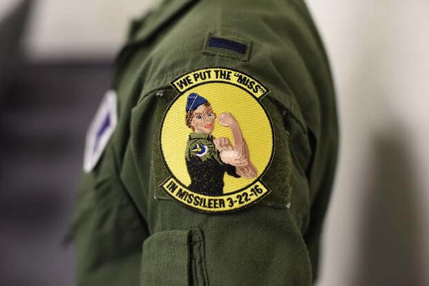 A missileer from Malmstrom Air Force Base, Mont., presents her patch after a training session at the missile procedures trainer. (U.S. Air Force/Airman Collin Schmidt)