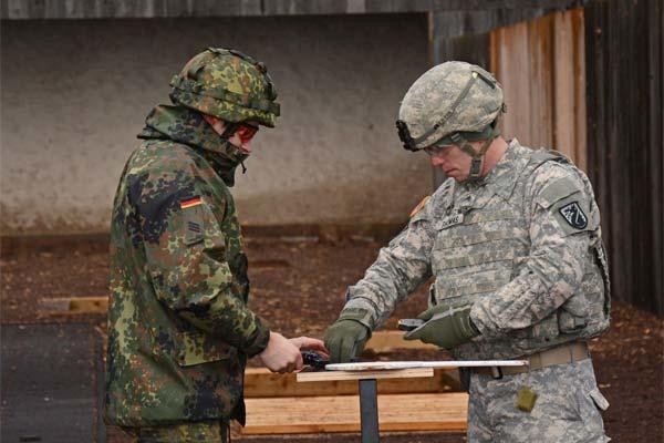 Sgt. Bryan G. Thomas helps Cpl. Manuel Marx, clerk, Public Affairs Office, Hessen State Command safely through each step of qualification process during a M9 combat pistol qualification range (Staff Sgt. Marshall R. Mason)