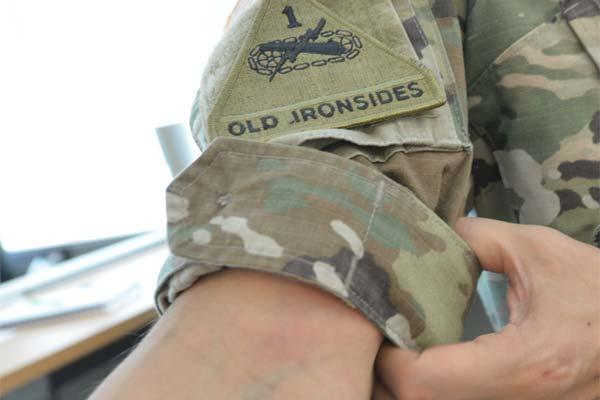 A Soldier demonstrates how the sleeves can be rolled with camo out, no more than three inches above the elbow. (Photo Credit: Gary Sheftick)