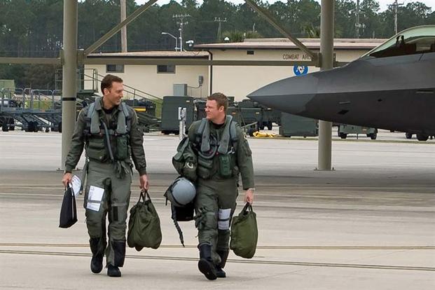 Maj. David Pifferario and Capt. Ryan Pelkola walk to their F-22 Raptors Feb. 4 at Tyndall Air Force Base, Fla. (U.S. Air Force photo/Scott Wolfe)